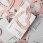Custom off-white specialty paper clothing store hang tags, custom women's clothing labels with logo designs, and custom men's clothing hang tags.